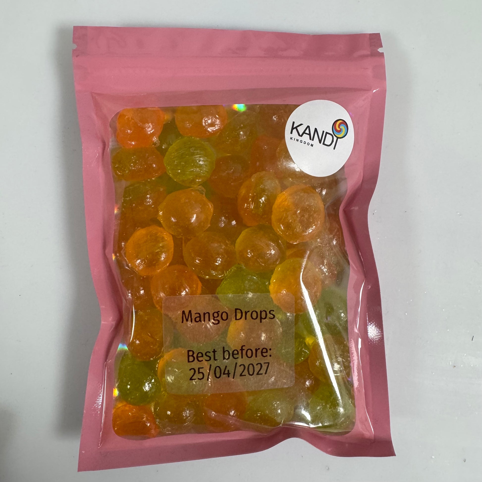 Pink package of Kandi Mango Drops with a best before date on a white background
